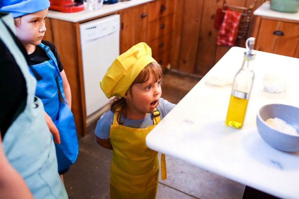 Jeunes enfants en tabliers colorés au comptoir de la cuisine